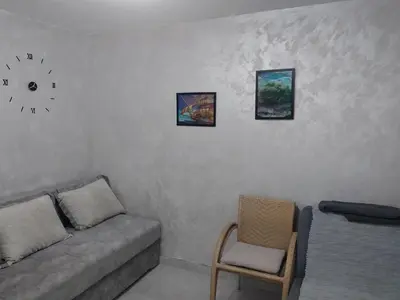 a living room with a couch and a clock on the wall at Drago Sutomore 2025 in Borča
