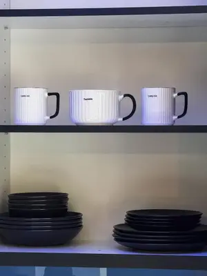 three coffee mugs and plates on a shelf at Prime Location Modern Luxury in Bohemian Skadarlija! in Belgrade