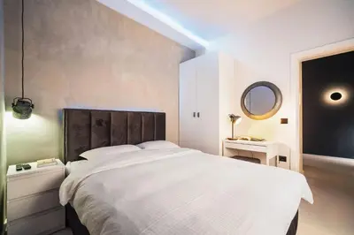 a bedroom with a large white bed and a mirror at Prime Location Modern Luxury in Bohemian Skadarlija! in Belgrade