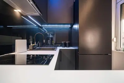 a kitchen with black cabinets and a refrigerator at Prime Location Modern Luxury in Bohemian Skadarlija! in Belgrade