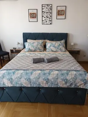 a large blue bed with two pillows on it at Mama in Belgrade
