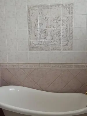 a bathroom with a bath tub and a tile wall at Apartman V Dedinje in Belgrade