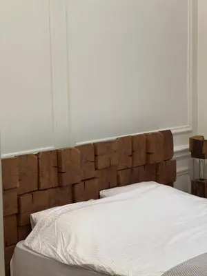 a bed with a wooden headboard in a bedroom at Apartman V Dedinje in Belgrade