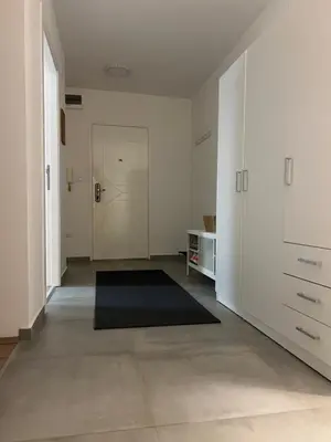 an empty room with a hallway with a door and a rug at Sassy in Belgrade