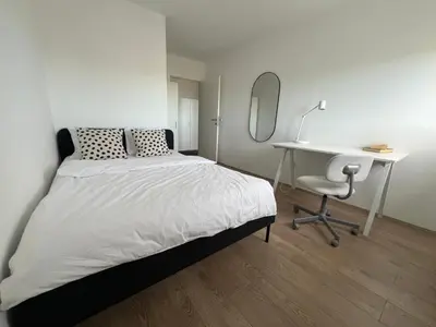 a bedroom with a bed and a desk and a mirror at Sassy in Belgrade