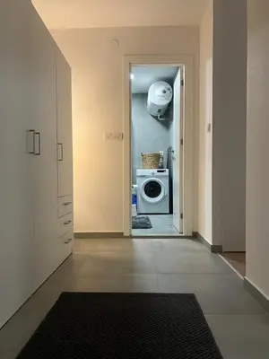 a hallway with a door to a kitchen with a washing machine at Sassy in Belgrade
