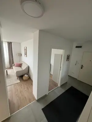 a white living room with a couch and a mirror at Sassy in Belgrade