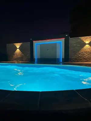 a swimming pool at night with a lit up door at Vikend house Cvrcak in Slankamenački Vinogradi