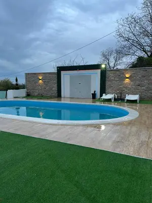 a swimming pool in front of a brick building at Vikend house Cvrcak in Slankamenački Vinogradi