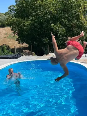 a person jumping into a swimming pool at Vikend house Cvrcak in Slankamenački Vinogradi