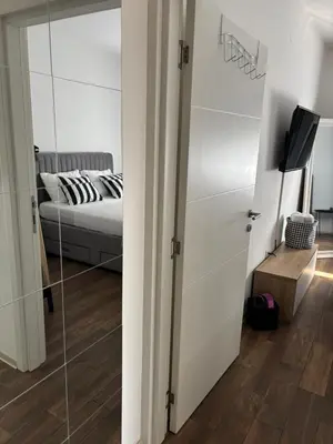 a bedroom with a bed and a sliding glass door at Apartman Idila in Ruma