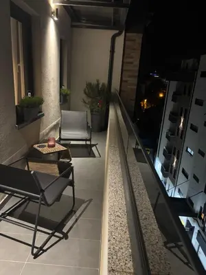 a room with two chairs and a table on a balcony at Apartman Idila in Ruma