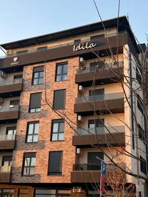 a building with a sign on the side of it at Apartman Idila in Ruma