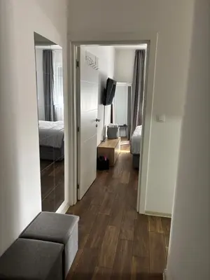 a hallway with a room with a bed and a mirror at Apartman Idila in Ruma