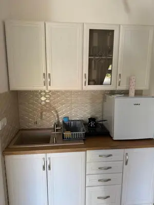 a kitchen with white cabinets and a sink and a microwave at Central in Pančevo