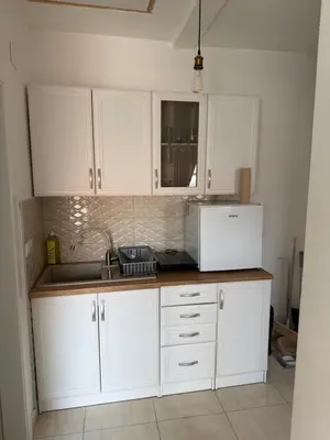 a kitchen with white cabinets and a sink and a microwave at Central in Pančevo