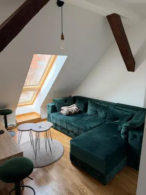 a living room with a green couch and a table at Central in Pančevo