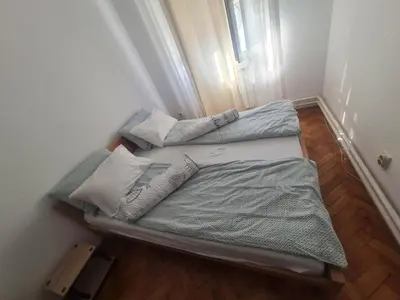 two beds in a small room with a window at Masha in Belgrade