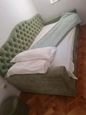 a bed with a green headboard and pillows on it at Masha in Belgrade