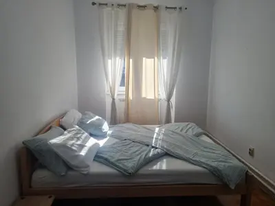 an unmade bed in a bedroom with a window at Masha in Belgrade