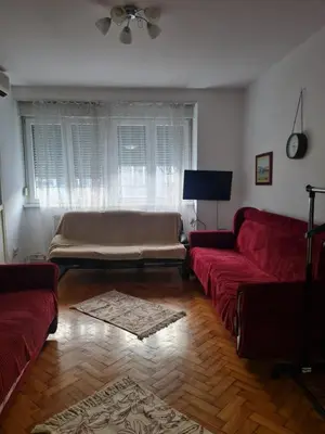 a living room with a red couch and a large window at Masha in Belgrade