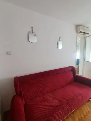 a red couch in a living room with two lights at Masha in Belgrade