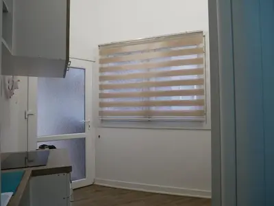 a kitchen with a window with a wooden blind at Terazije apartment in Belgrade