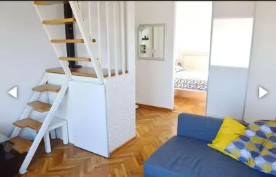 a living room with a staircase and a blue couch at Vesna apartment in Belgrade
