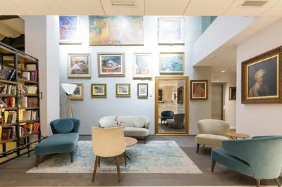 a living room with chairs and paintings on the wall at Envoy Hotel in Belgrade