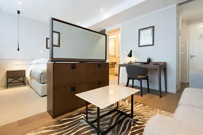 a living room with a flat screen tv on a dresser at Envoy Hotel in Belgrade