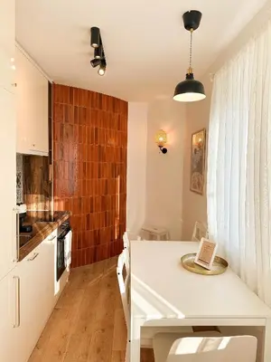 a kitchen with a white table in a room at Marasca Belgrade - Cozy, Chic & Nomad-friendly Flat in Downtown in Belgrade