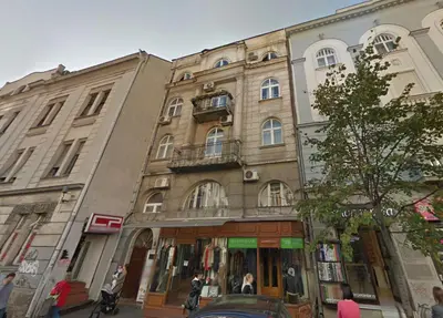 a building on the corner of a street with people in front at Marasca Belgrade - Cozy, Chic & Nomad-friendly Flat in Downtown in Belgrade