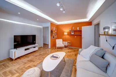 a living room with a couch and a tv at Marasca Belgrade - Cozy, Chic & Nomad-friendly Flat in Downtown in Belgrade