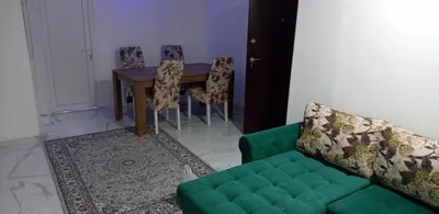 a living room with a green couch and a table at melvina 2 in Pančevo