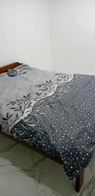 a bed with a black and white bedspread with trees on it at melvina 2 in Pančevo