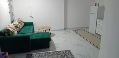a living room with a green couch and a table at melvina 2 in Pančevo