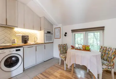 a kitchen with a table and a washing machine at Emi Quiet & Cozy Stay in Belgrade