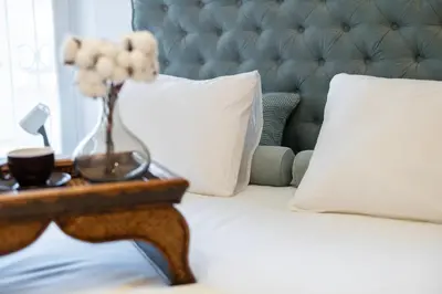 a bed with a table with a vase of flowers on it at Emi Quiet & Cozy Stay in Belgrade