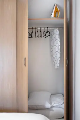 a closet with a wooden door and a bed at Emi Quiet & Cozy Stay in Belgrade