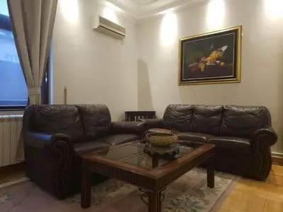 a living room with a leather couch and a coffee table at Apartment Eleon in Belgrade