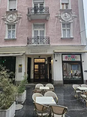 a group of tables and chairs in front of a building at Apartment Eleon in Belgrade