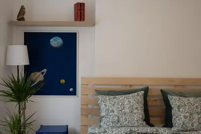 a bedroom with a bed and a painting of the moon at Belgrade Urban Central Flat in Belgrade