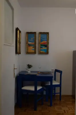 a blue table with two chairs and a cross on the wall at Belgrade Urban Central Flat in Belgrade