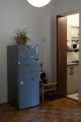 a blue refrigerator in a kitchen with a plant on top at Belgrade Urban Central Flat in Belgrade