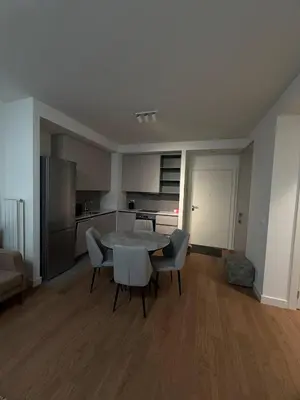 a living room with a table and chairs and a kitchen at Belgrade Waterfront Apartment in Belgrade