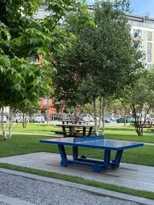 a blue picnic table in a park with a bench at Belgrade Waterfront Apartment in Belgrade