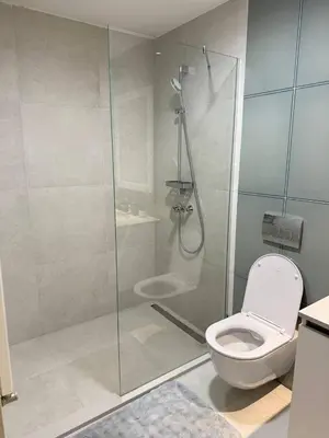 a bathroom with a glass shower with a toilet at Belgrade Waterfront Apartment in Belgrade