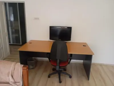 a desk with a computer monitor and a chair at Padina-Kovacica in Padina