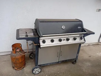 a grill sitting on a cart next to a wall at Padina-Kovacica in Padina