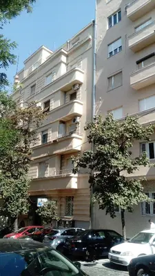 a tall building with cars parked in front of it at Belle Apartments - Square 8 in Belgrade